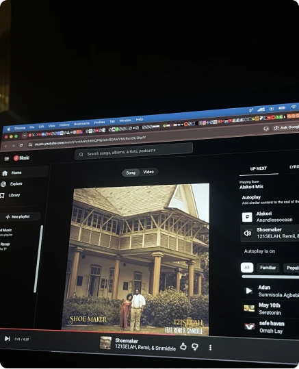 A laptop playing a song on YouTube Music in a dark room